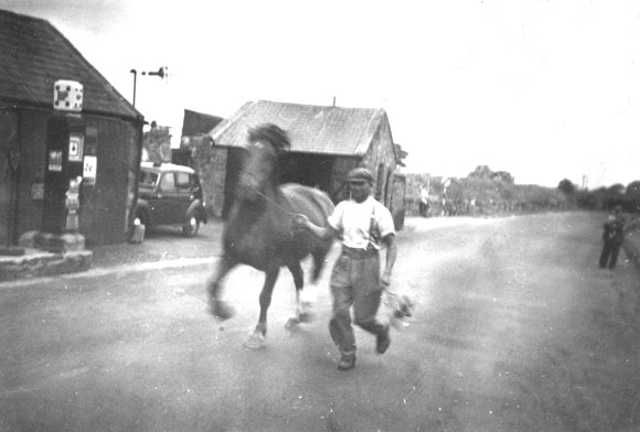 An old photo taken by my dad or mum of one of the locals showing off his horses outside the pub garage